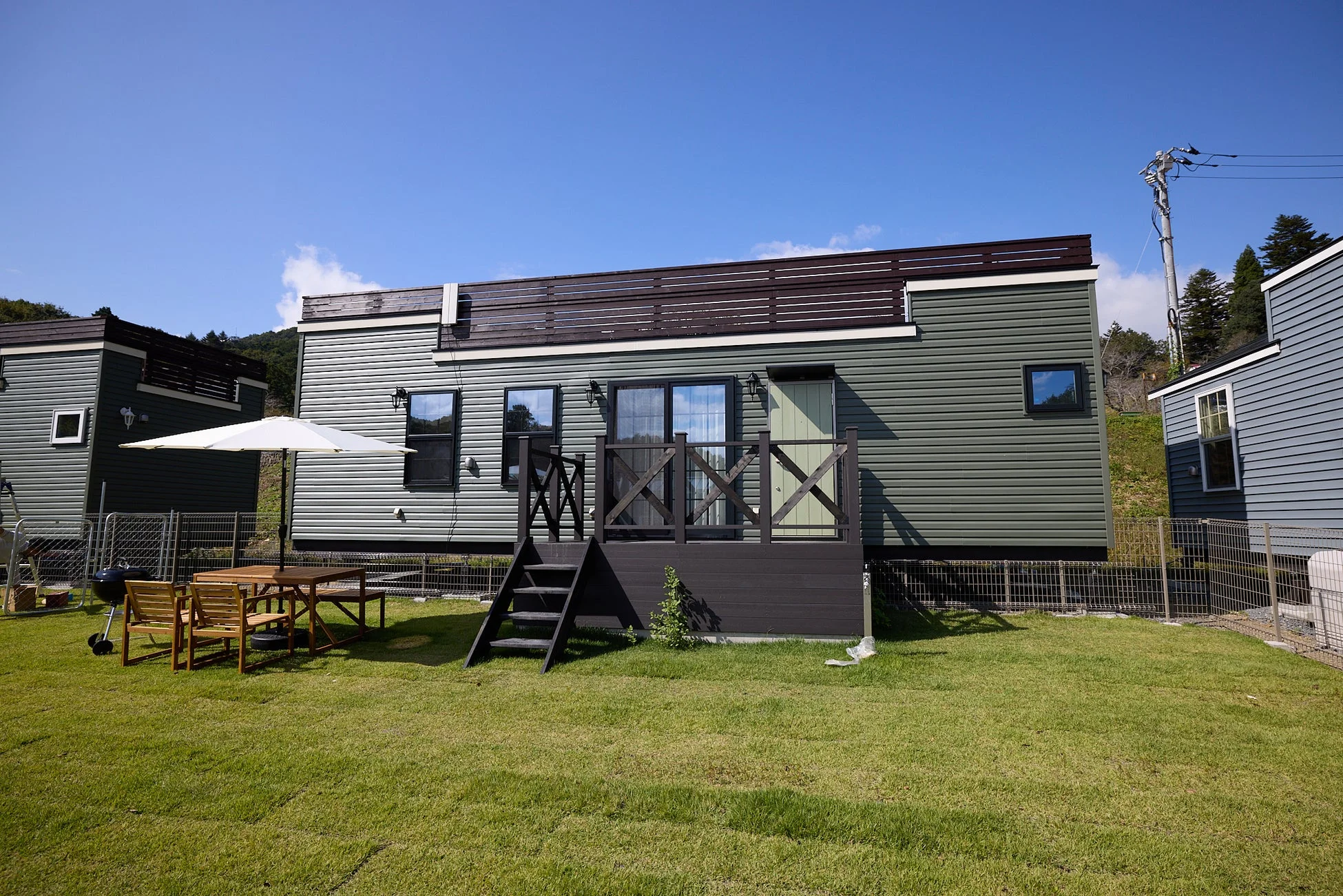 広々とした芝生の庭を持つモダンなコテージ