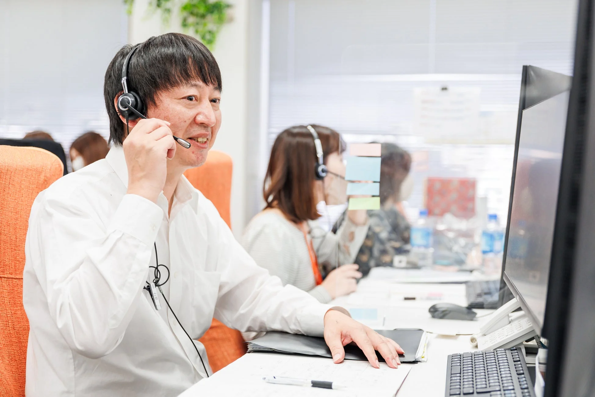 コールセンターで対応する男性スタッフ